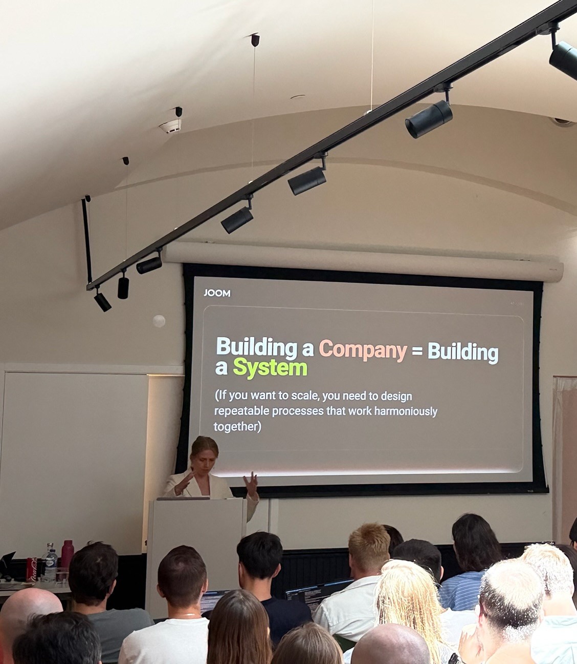 Lena presenting to a full room of managers during the 3-day AI training intensive at Joom's Management Week in Lisbon